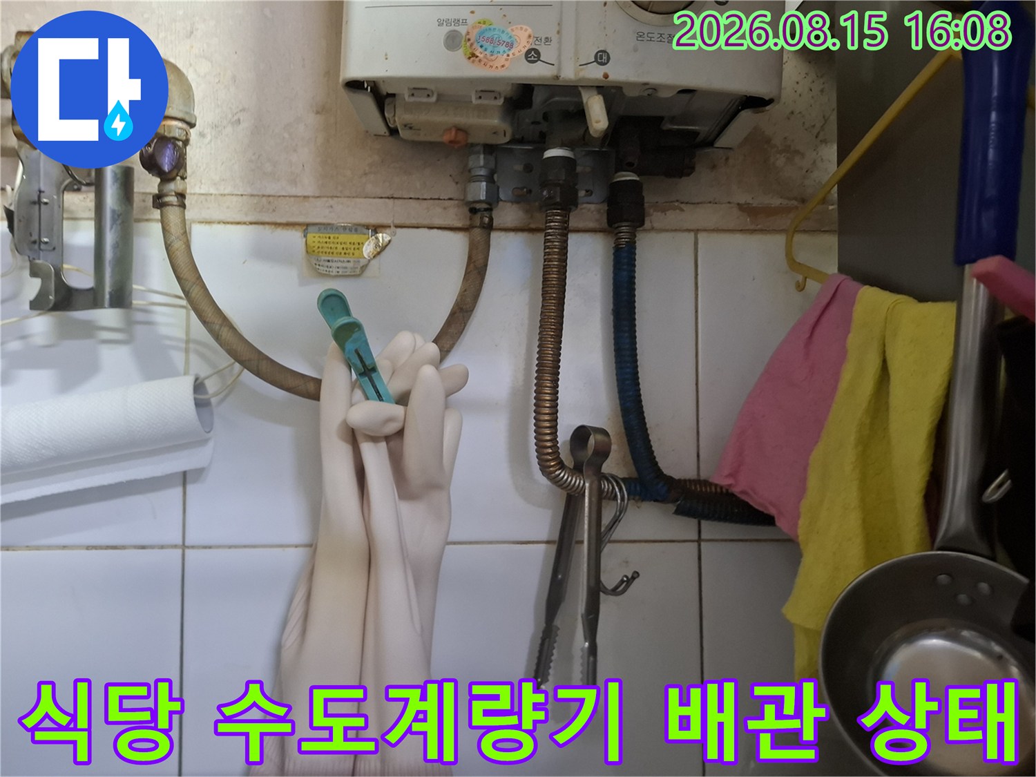 상암동 식당 내 설치된 수도계량기와 연결된 금속 배관의 모습입니다.