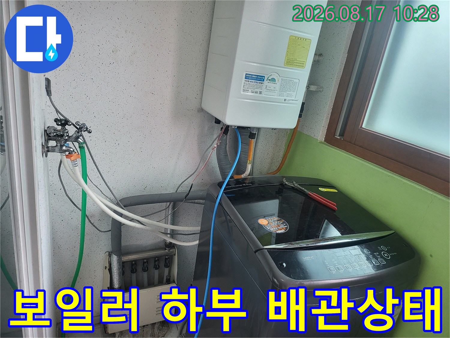 보일러와 세탁기 주변의 복잡한 배관 구조를 보여주는 사진입니다.