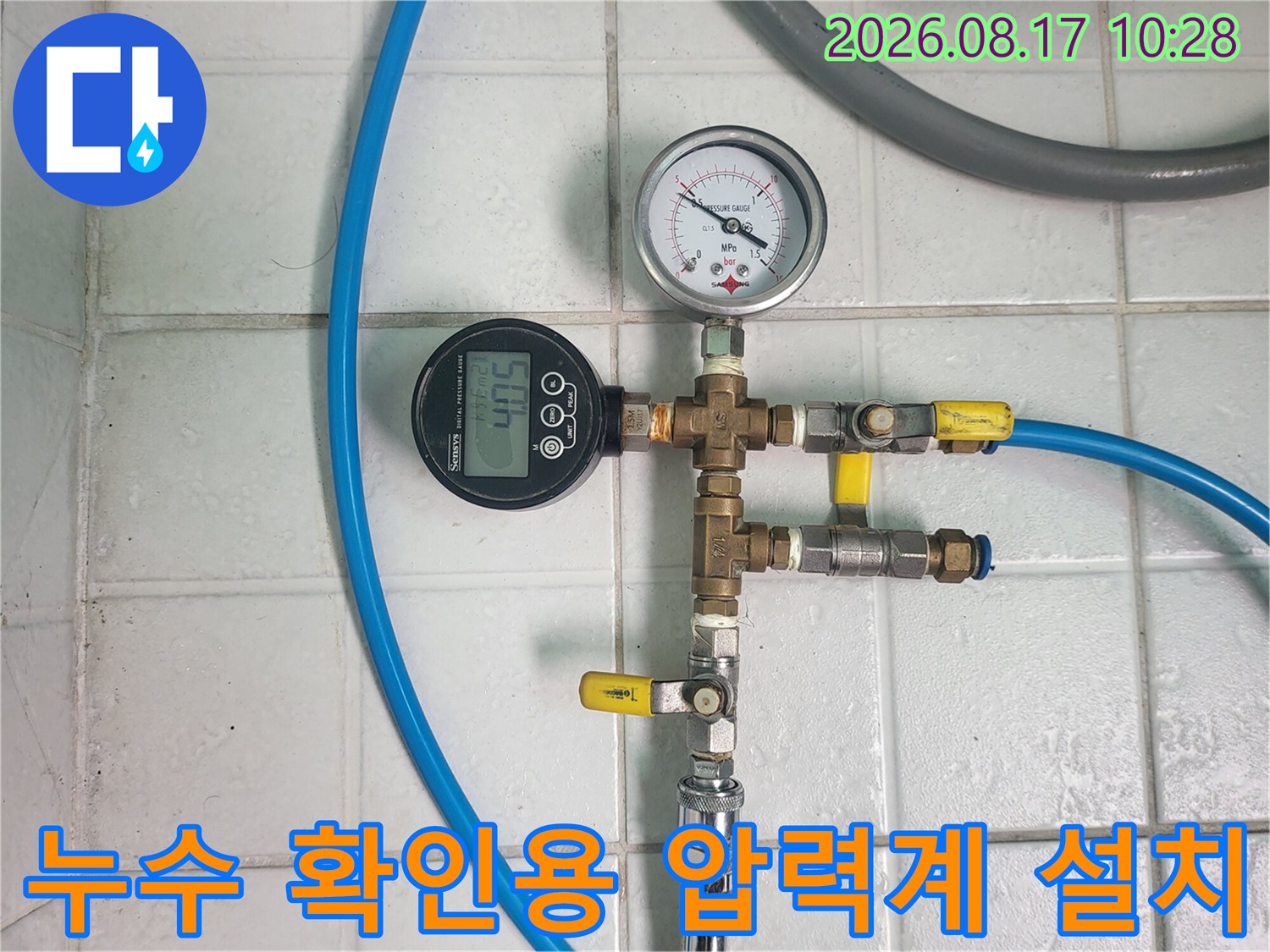 파란색 호스와 게이지가 연결된 배관 점검 장비