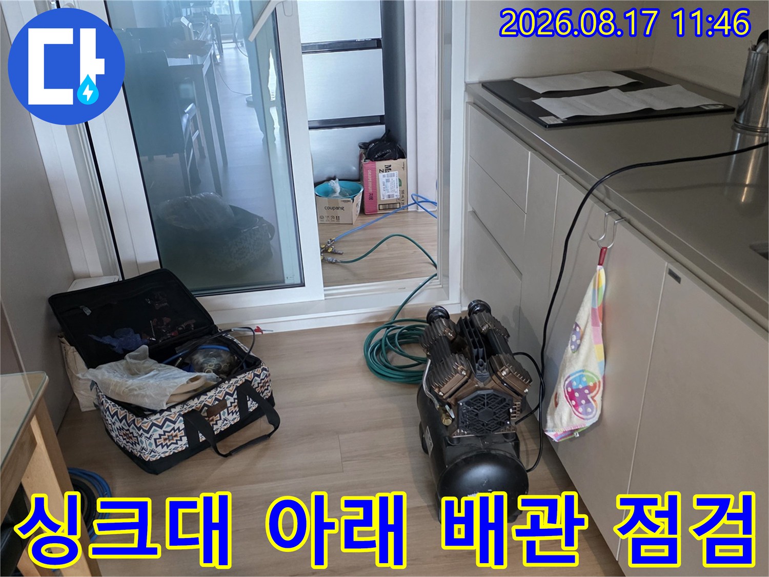 싱크대 하부장 밑으로 연결된 배수 호스와 누수 진단 도구의 모습입니다.