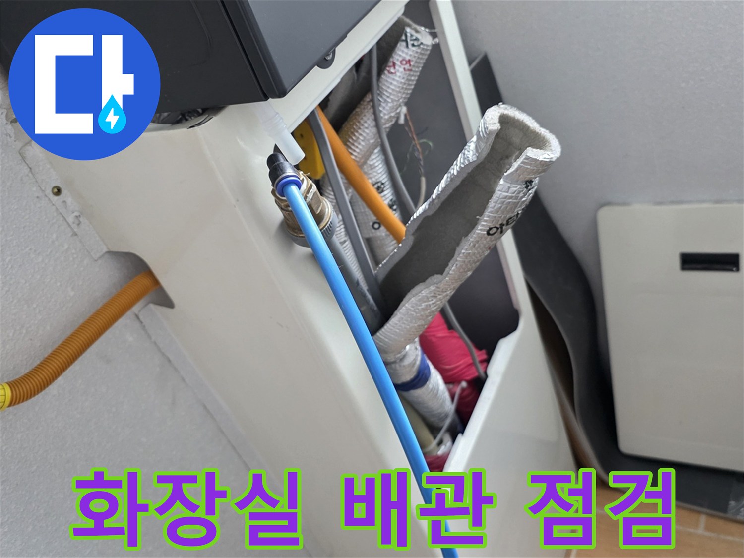 화장실 천장 내부의 파란색 배관과 보온재가 감긴 배관 상태를 보여주는 사진