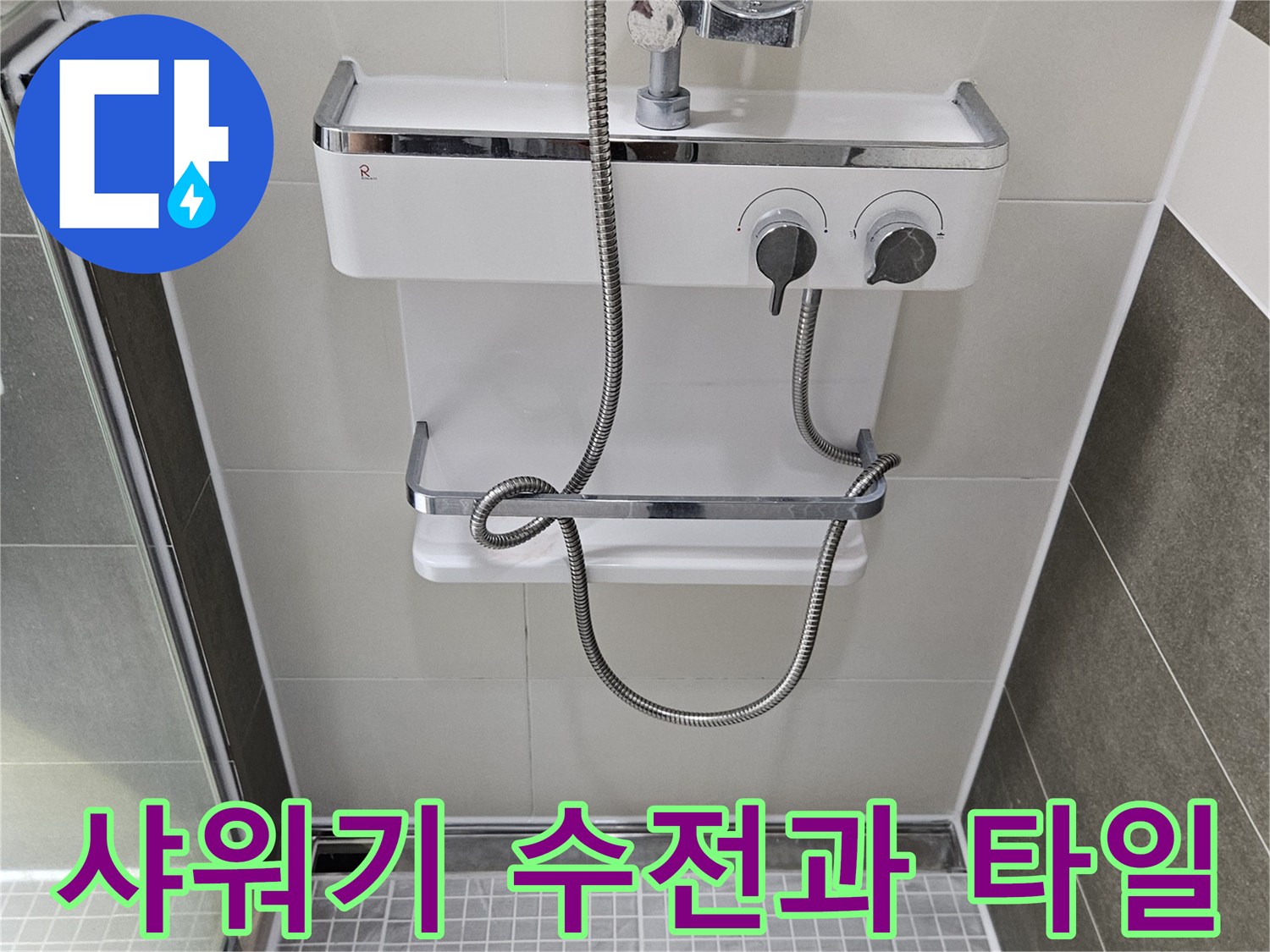 욕실 벽면 샤워기 수전과 은색 샤워 호스 모습입니다.