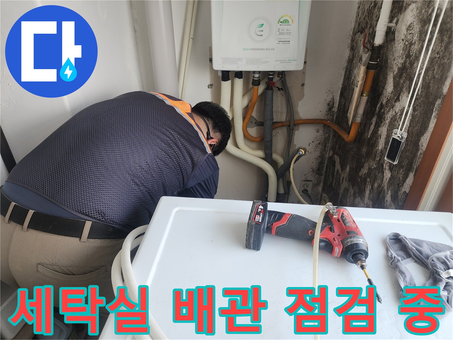 세탁실 벽면의 노란색 배관과 곰팡이가 발생한 벽면 상태를 확인하는 모습
