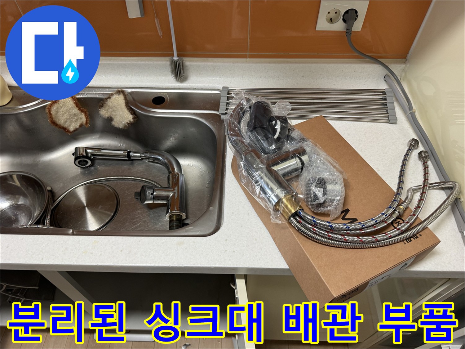 싱크대 아래쪽에서 분리된 금속 소재의 배관 부품들