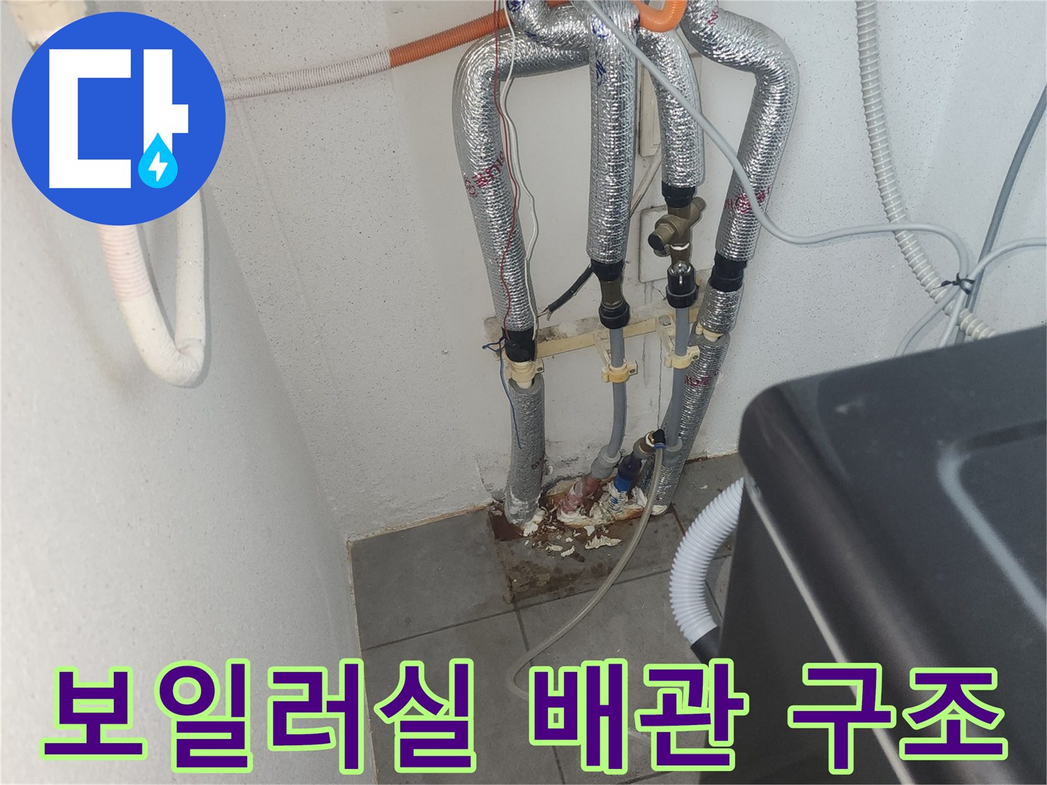 복잡하게 연결된 보일러실 배관과 벽면 타일 부위를 촬영한 사진입니다.
