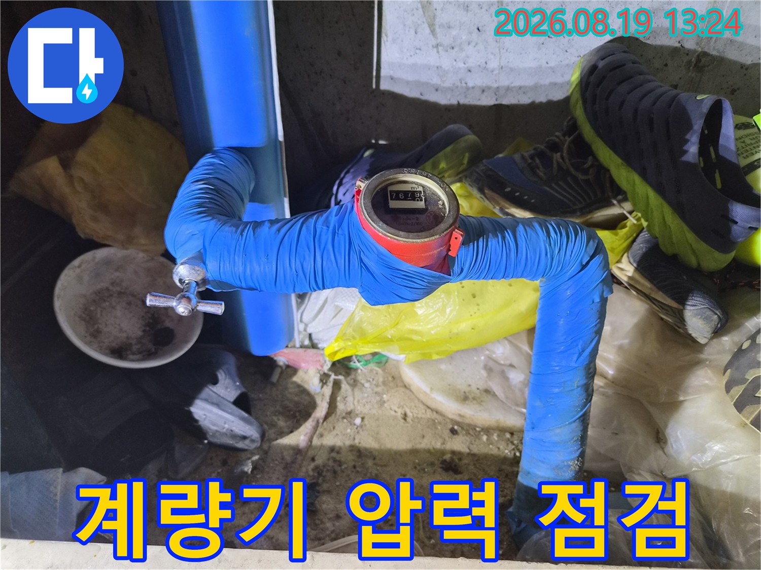 파란색 배관 마감재와 숫자가 보이는 수도 계량기의 근접 촬영입니다.