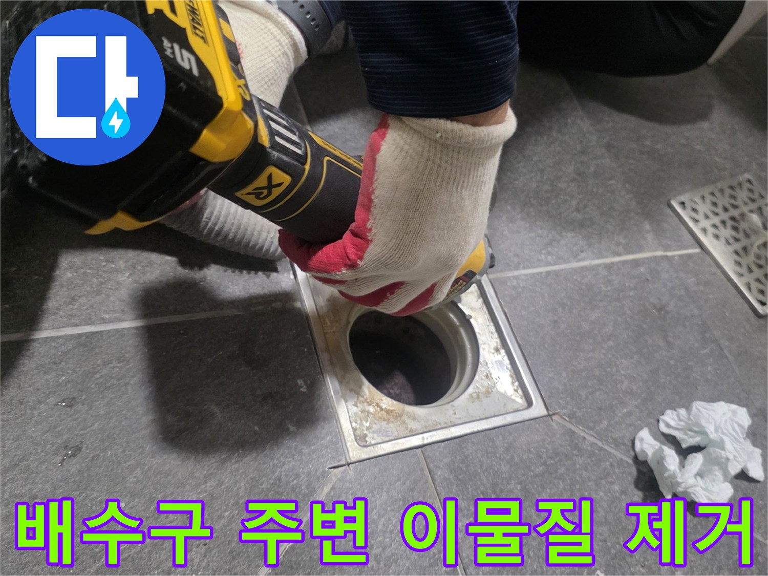 작업자가 장비를 사용하여 배수구 주변의 노후된 방수층을 정리하고 있습니다.