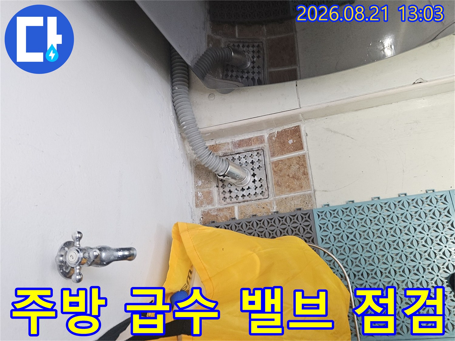 싱크대 하단-벽면 수도 밸브와 배수 호스 상세 모습