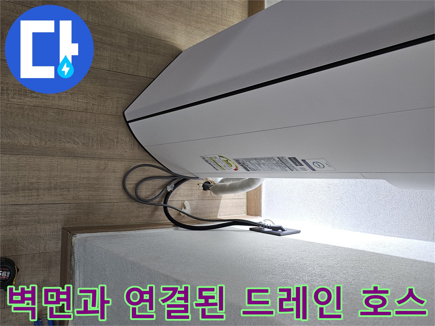 에어컨 하단에서 벽면으로 이어지는 배수관의 배치 모습입니다.