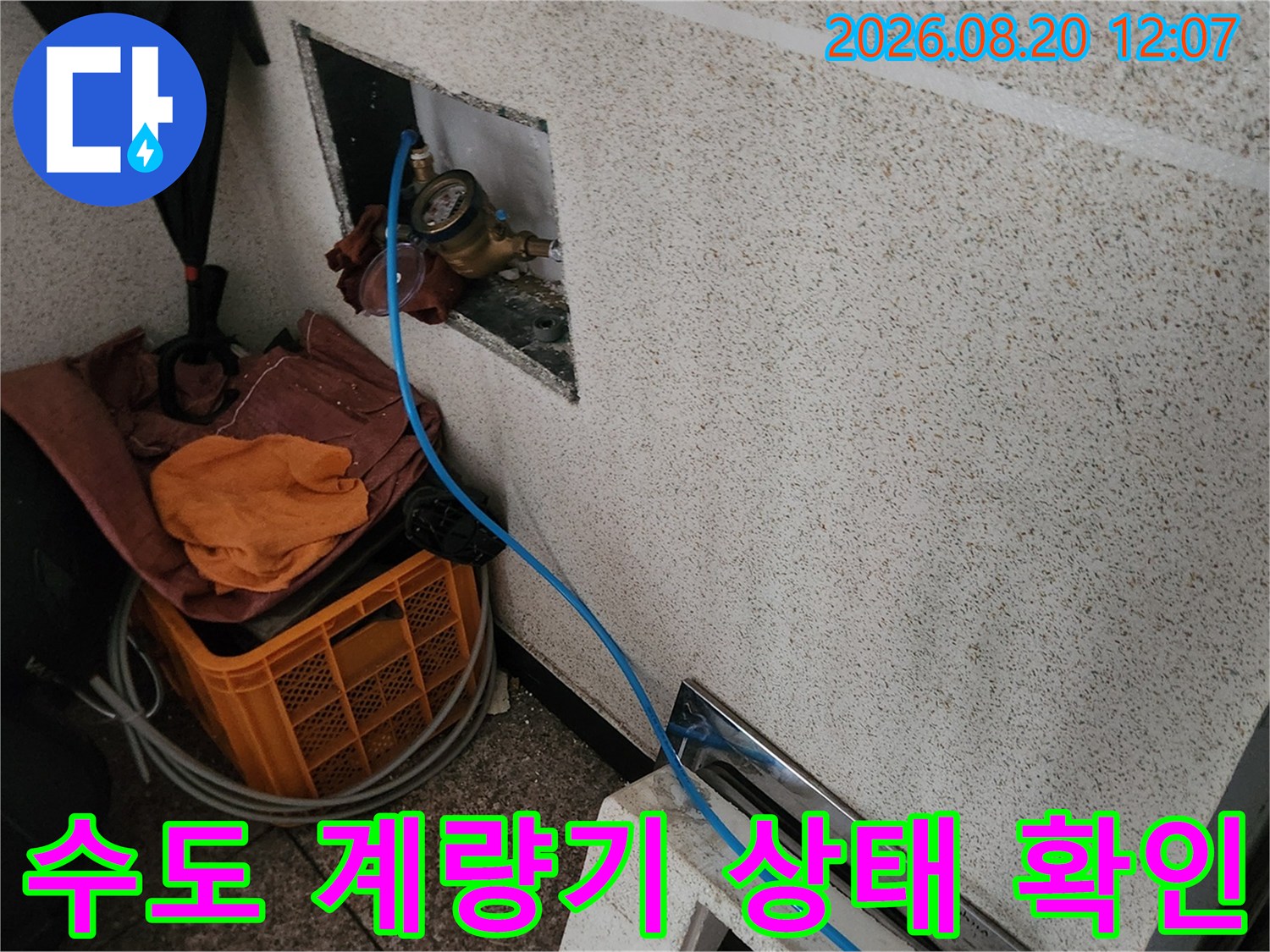 벽면 함 내부에 노출된 수도 계량기와 연결 배관의 모습입니다.