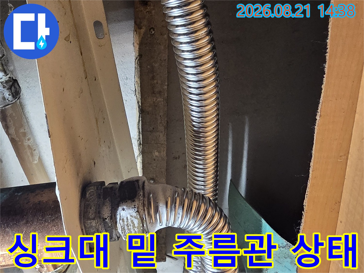 은색 주름관이 연결된 싱크대 하단 배관 구조물