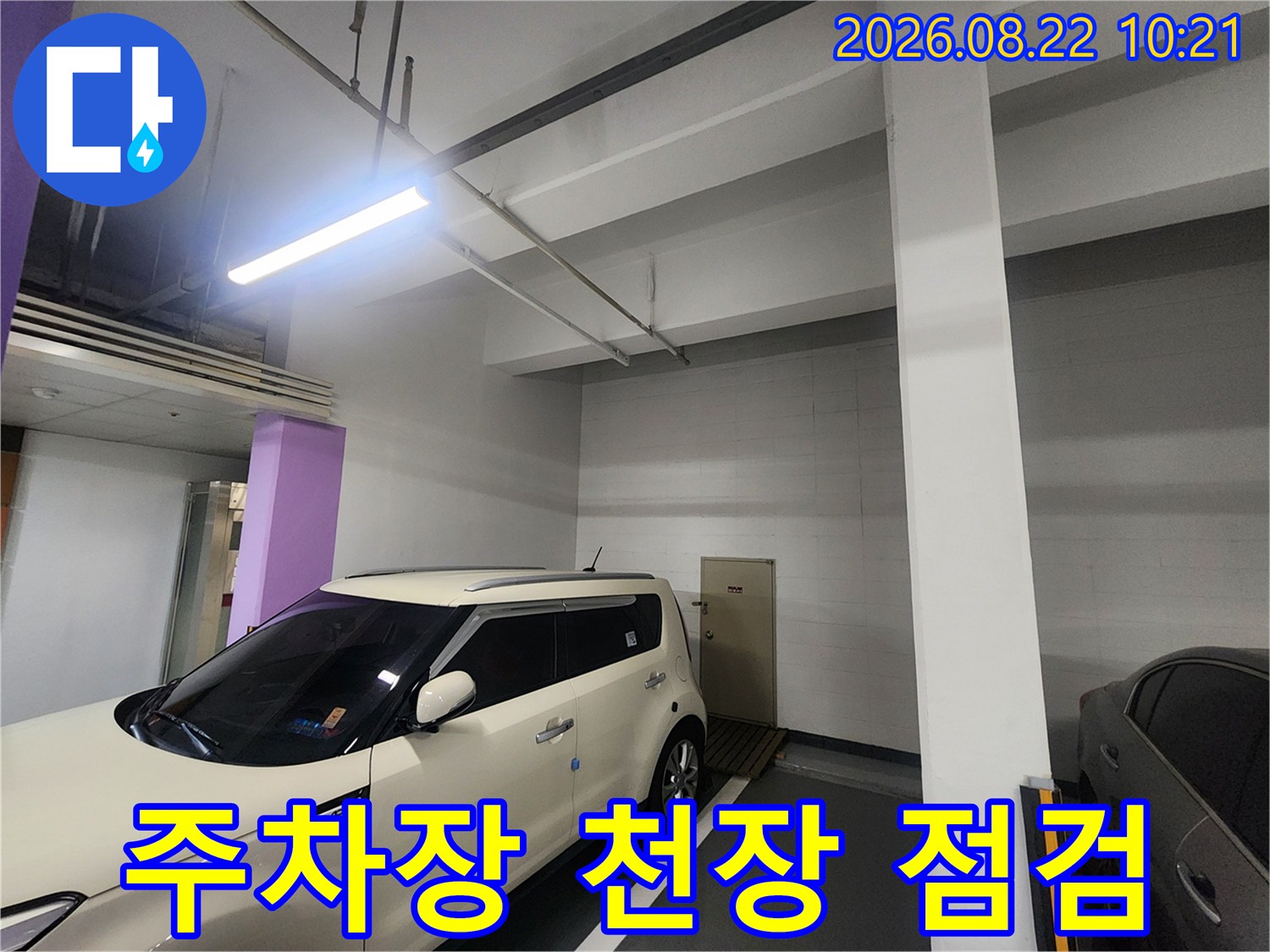 지하주차장 넓은 공간-천장 구조물과 주차된 차량의 모습