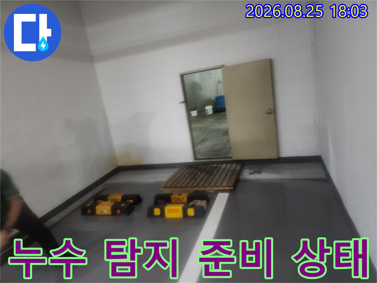 누수 지점을 찾기 위해 바닥에 배치된 전문 장비와 점검 중인 공간입니다.