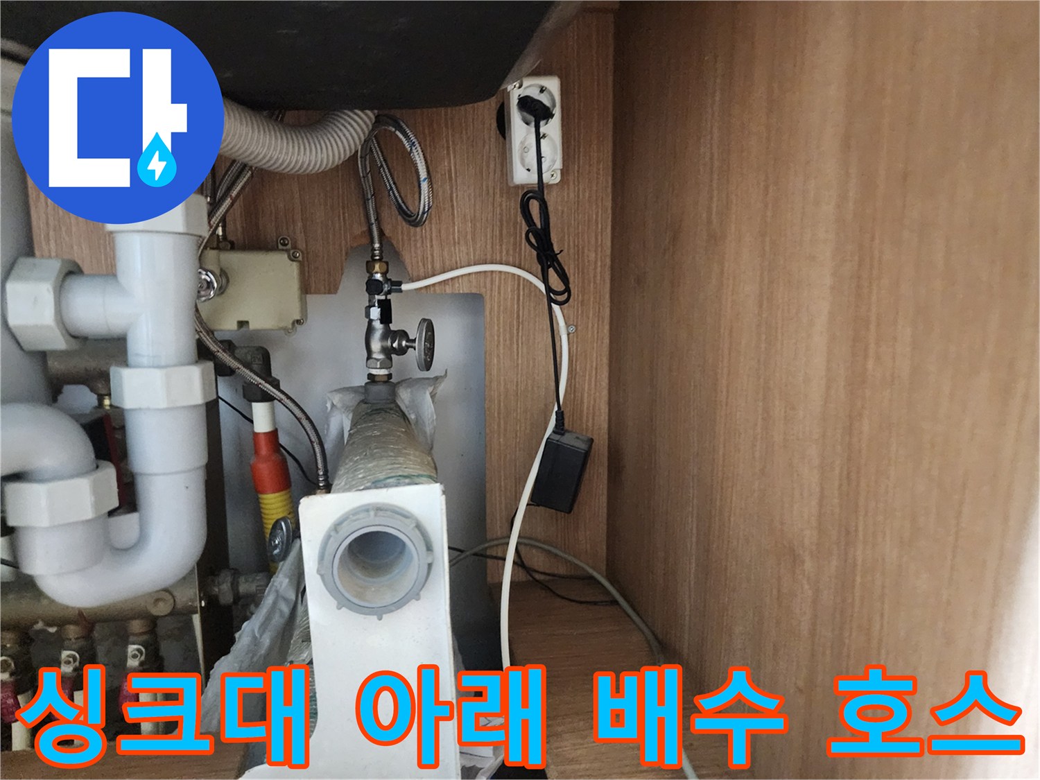 싱크대 하부의 굴곡진 호스와 수직으로 연결된 배수 관로
