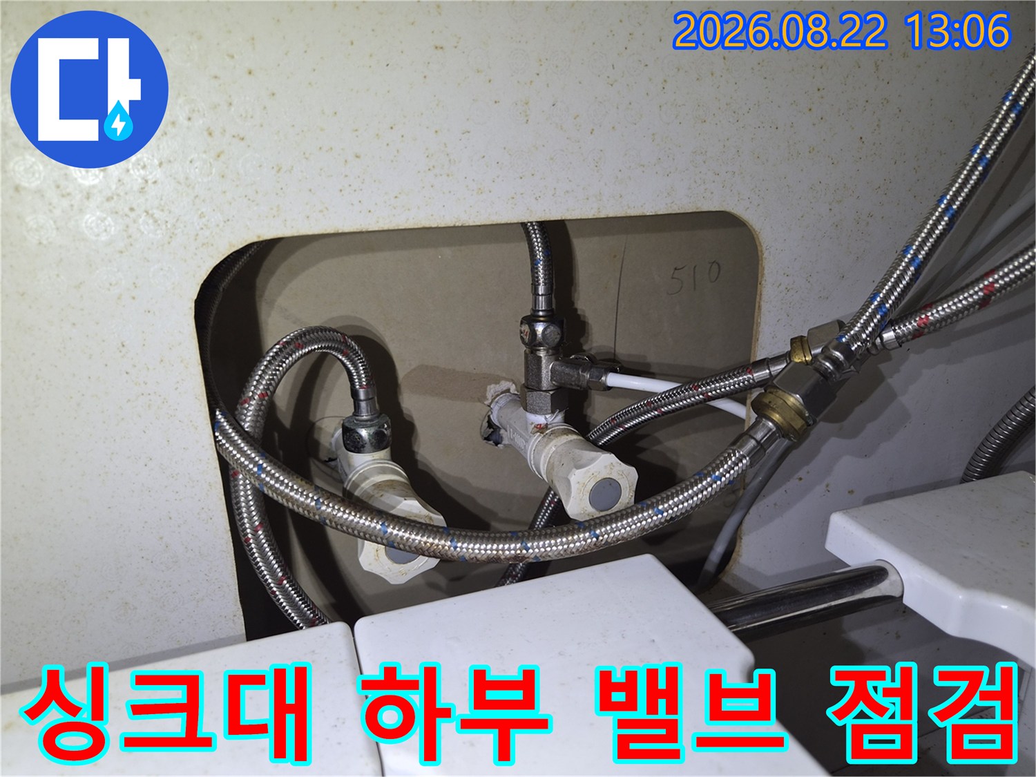 싱크대 아래 금속 호스와 수전 연결 부위의 상세 모습입니다.