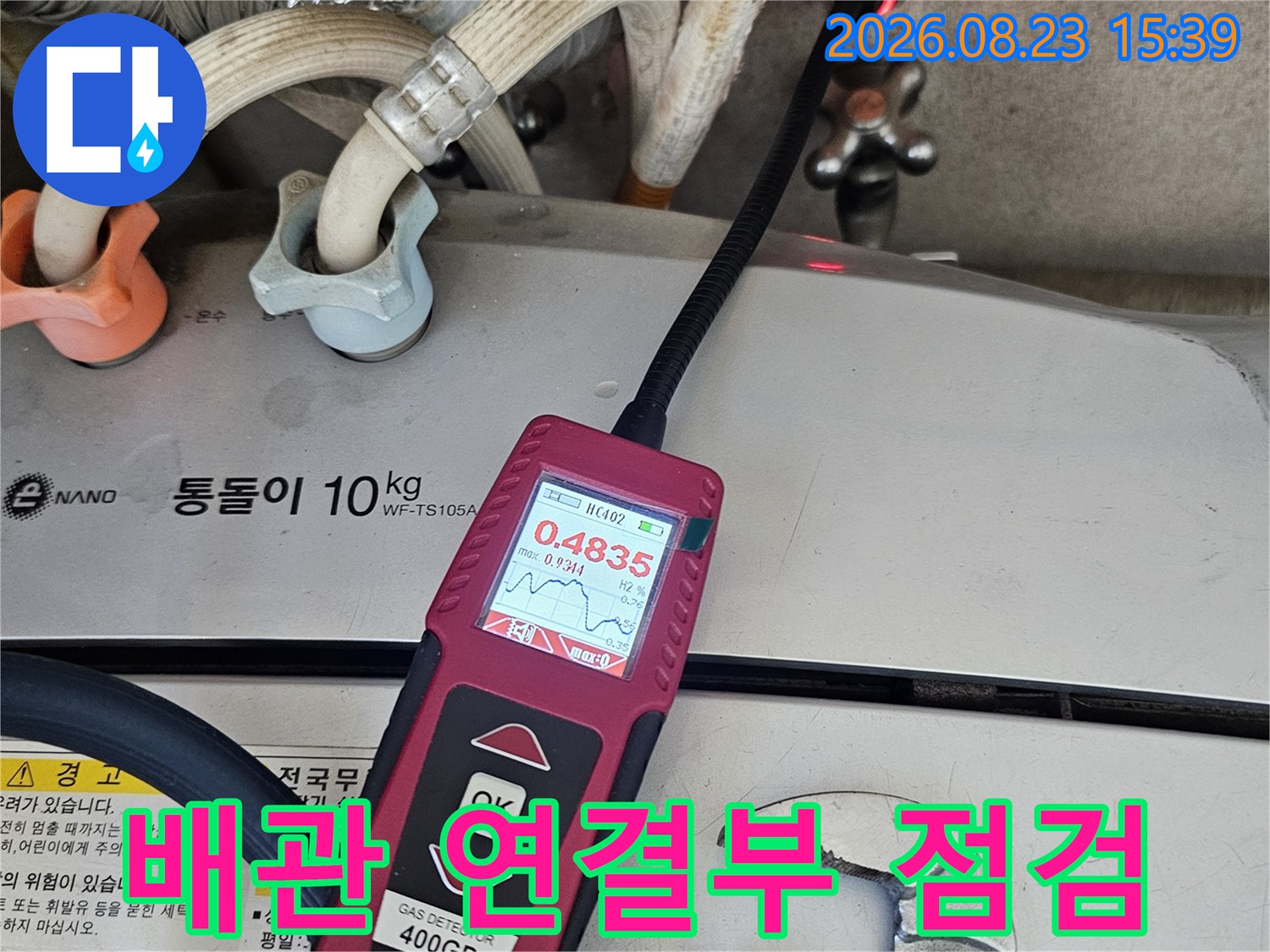 연결 부위 근처에서 가스 탐지기로 압력을 정밀하게 측정하고 있습니다.
