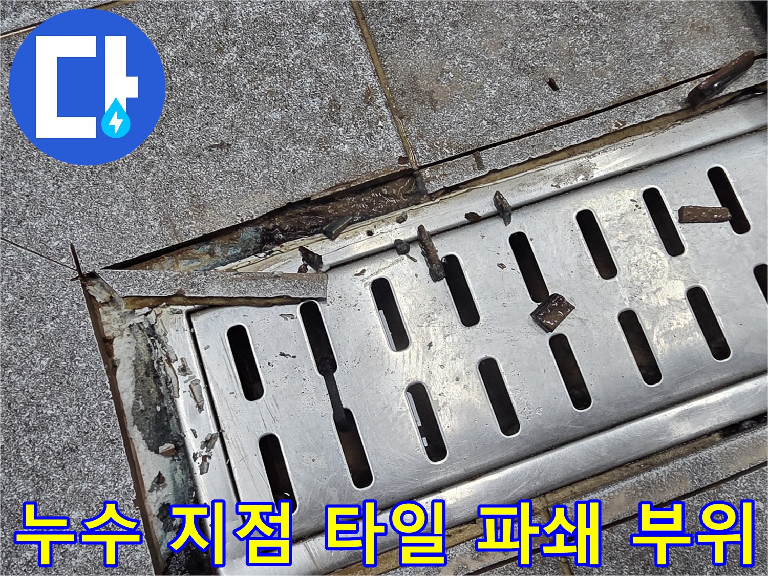 배수구 주변의 깨진 타일과 노출된 배수구 구조물