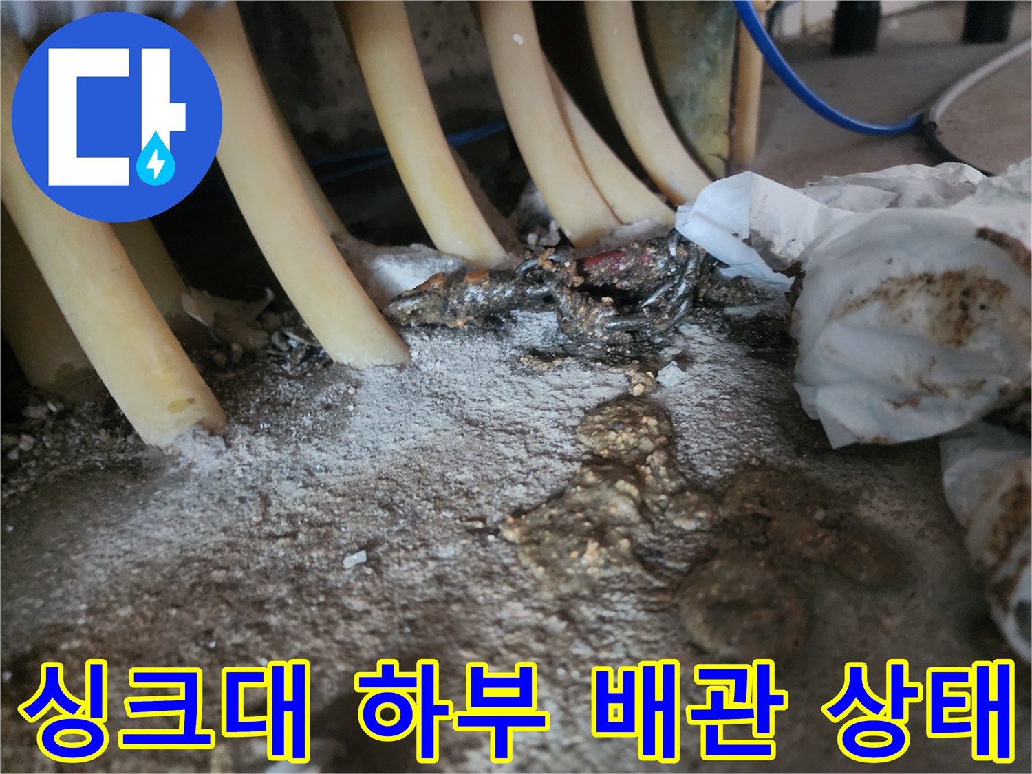 싱크대-하단-복잡한-배관과-이물질로-오염된-바닥-상태