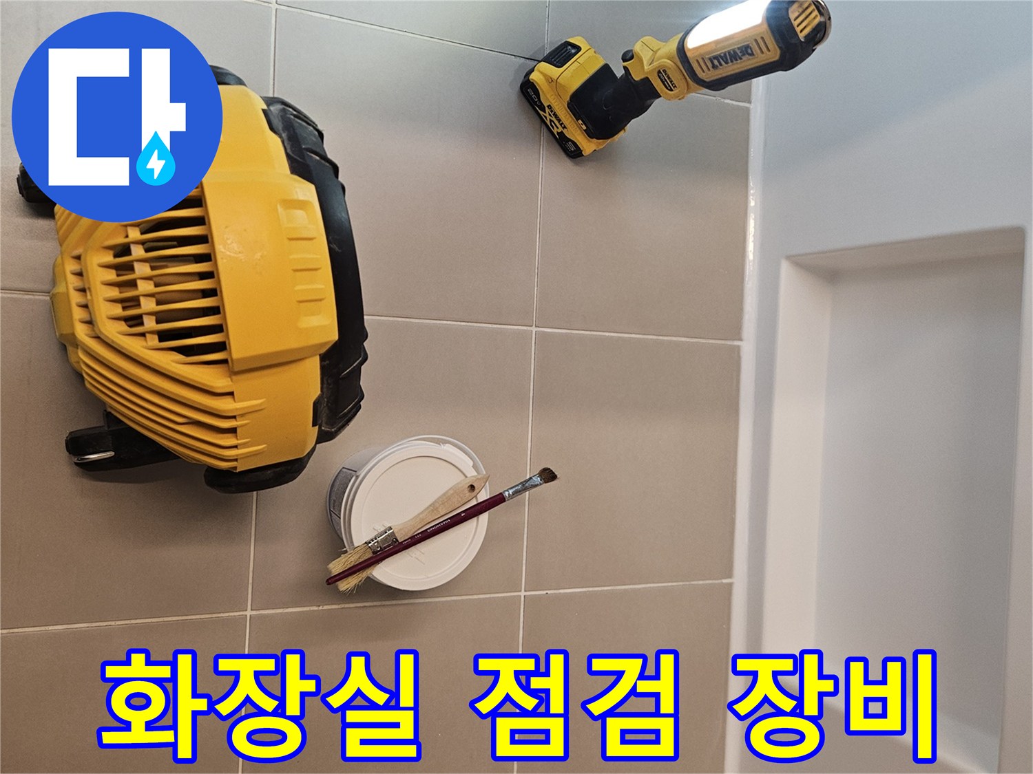 화장실 바닥 타일 점검을 위해 배치된 작업용 조명과 도구들