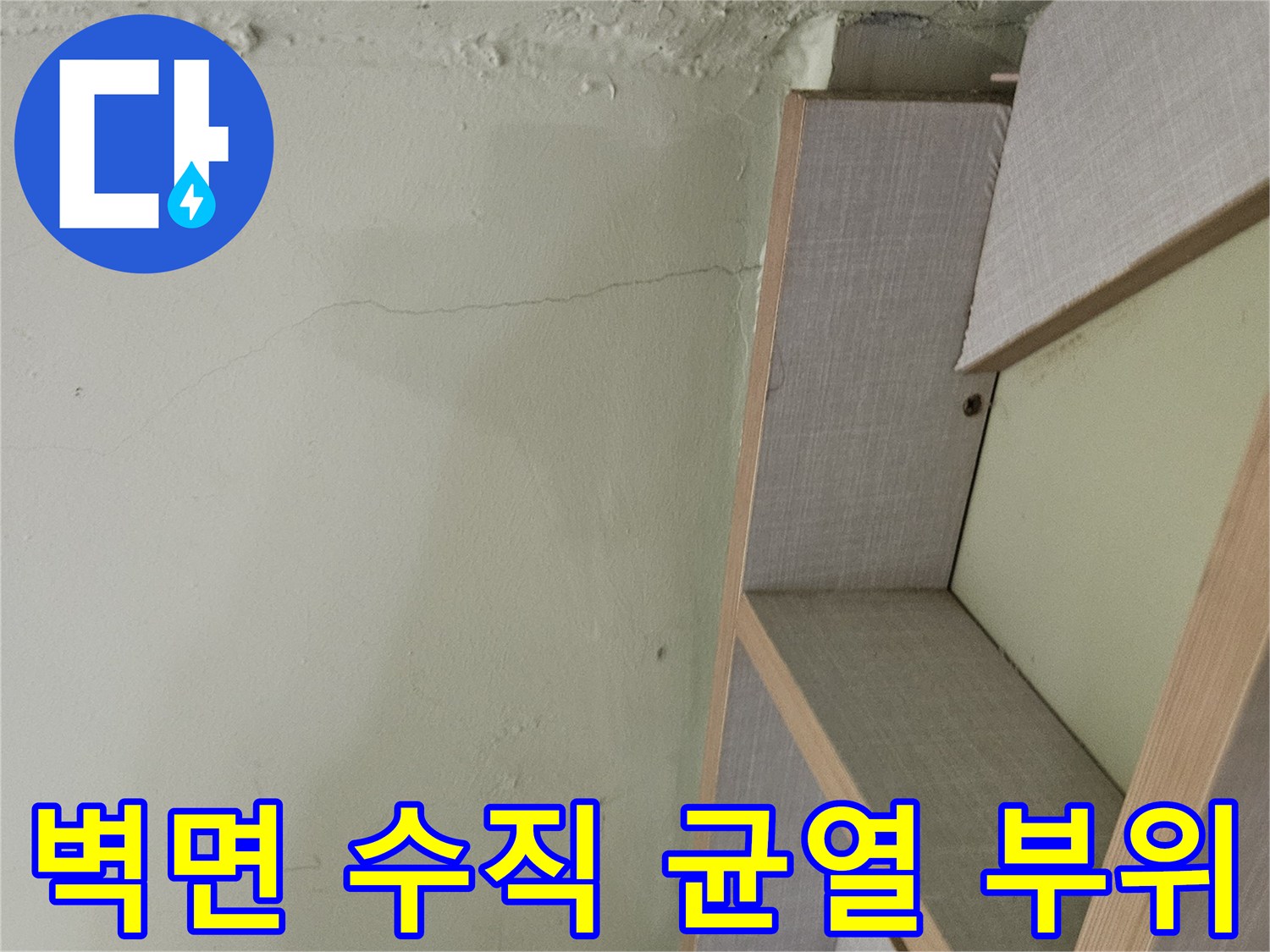 계단 구조물과 연결된 벽면의 수직 균열 및 습기 노출 지점