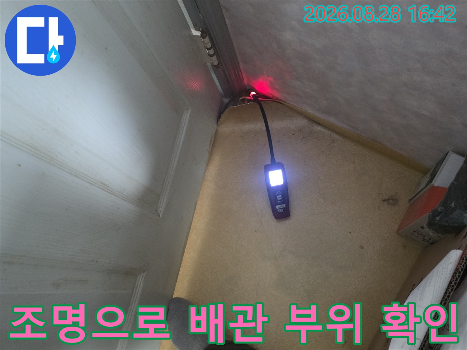 어두운 구석-배관 연결 부위의 습기를 확인하기 위한 조명 작업
