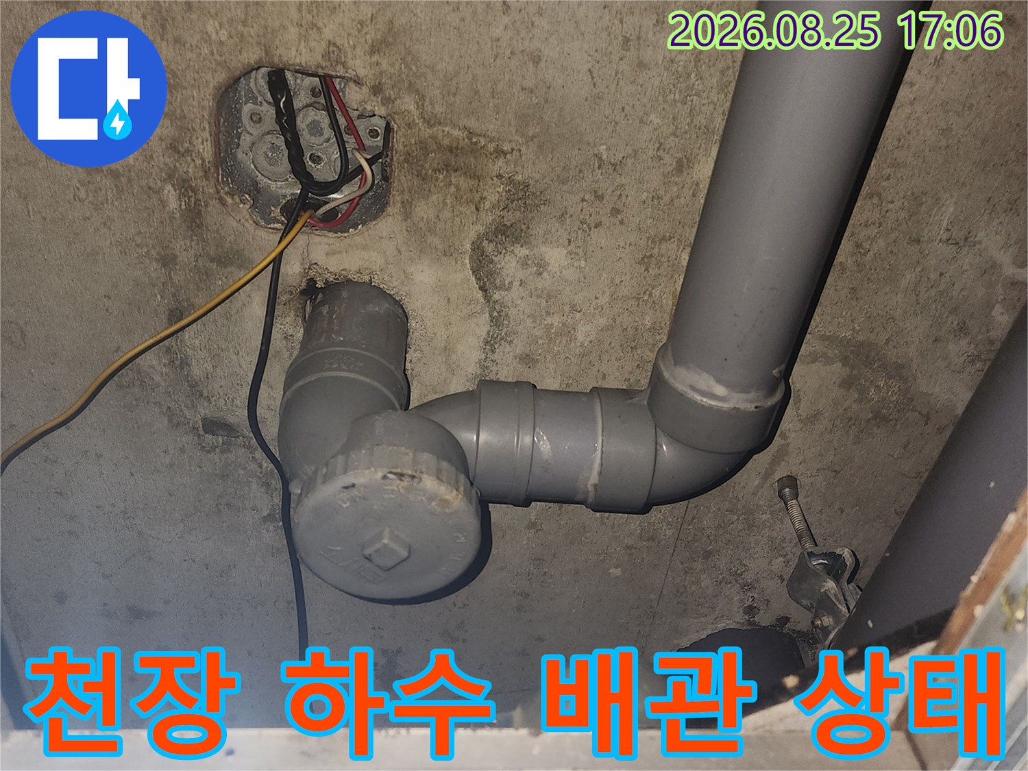 아파트 천장에 설치된 회색 하수 배관과 연결 부속의 상세 모습입니다.