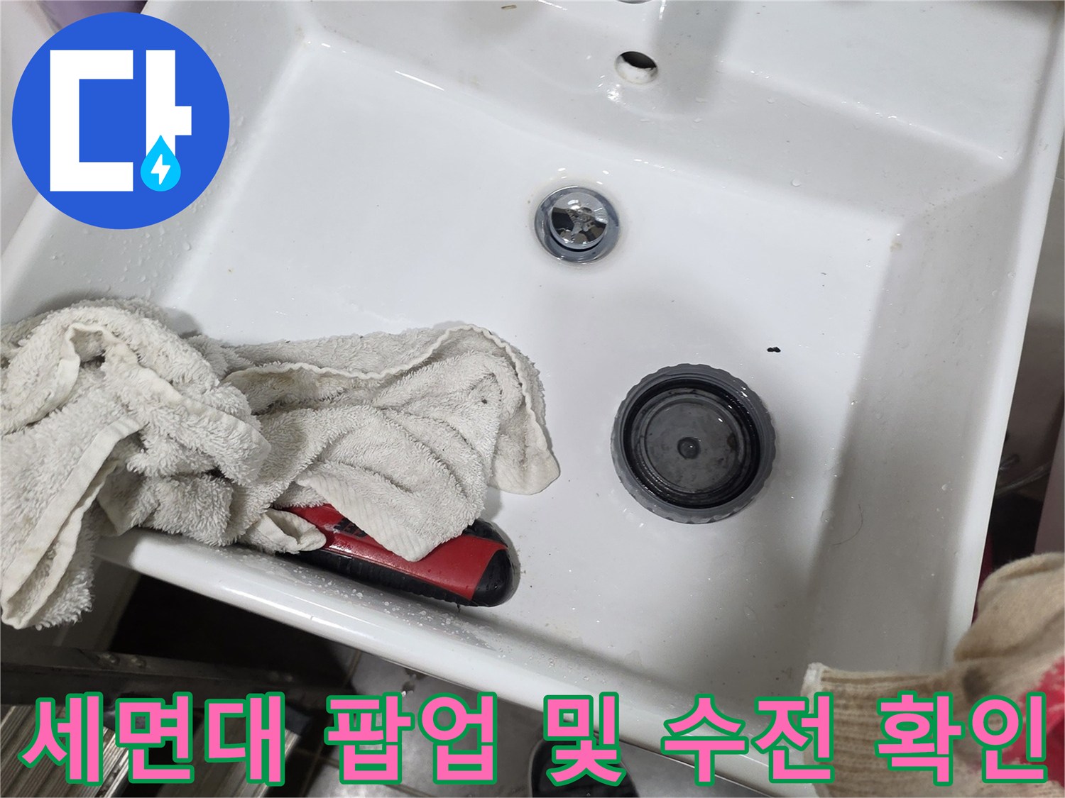 세면대 하부의 팝업과 수전 연결 부위를 촬영한 사진