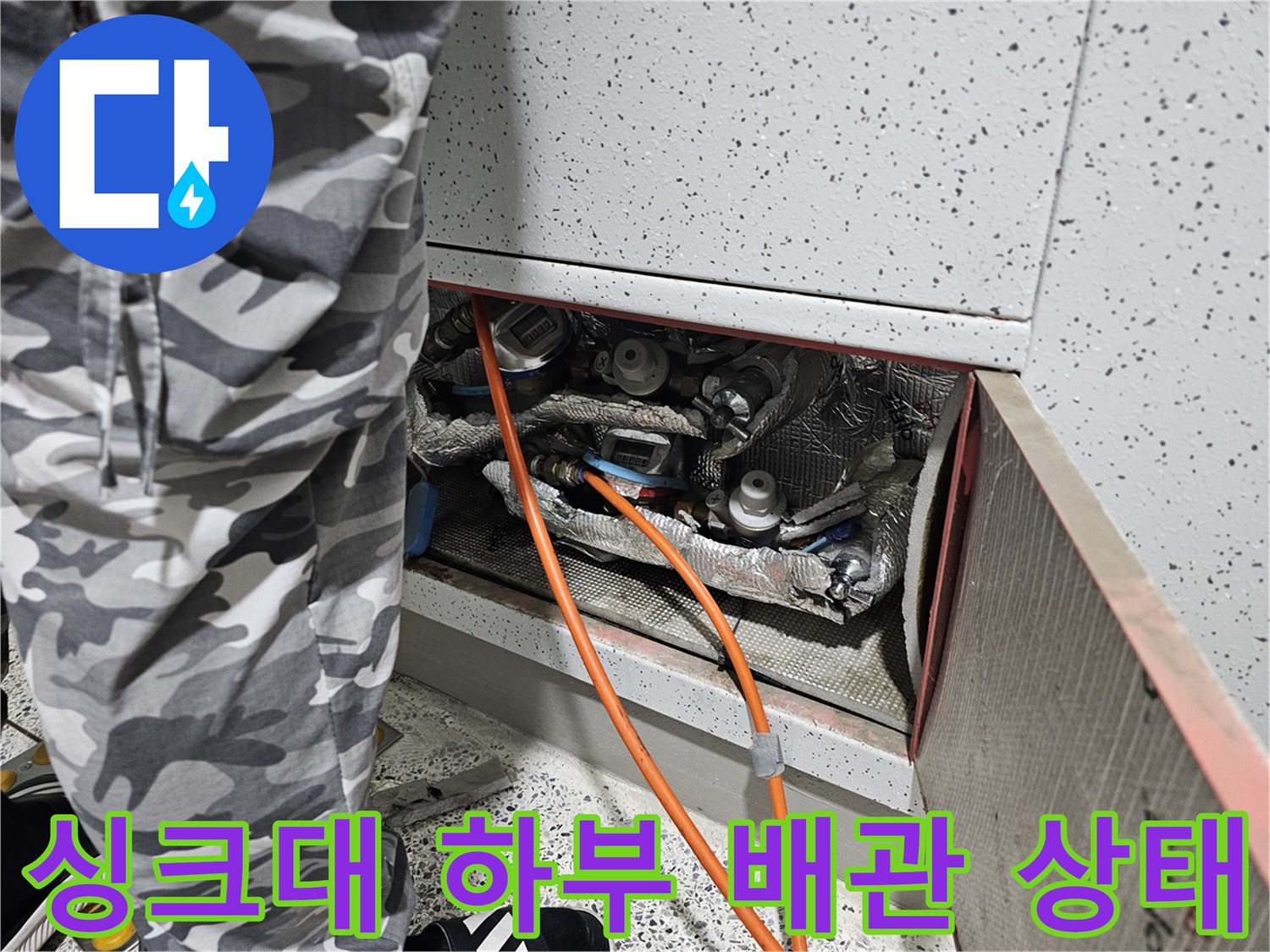 싱크대 아래쪽 은박 보온재로 감싸진 배관 부위 - 누수 확인 작업