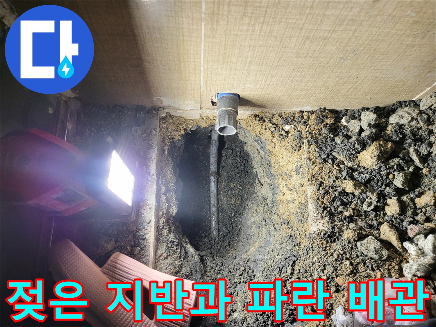 배관 주변의 젖은 흙과 노출된 오수관 연결 부위