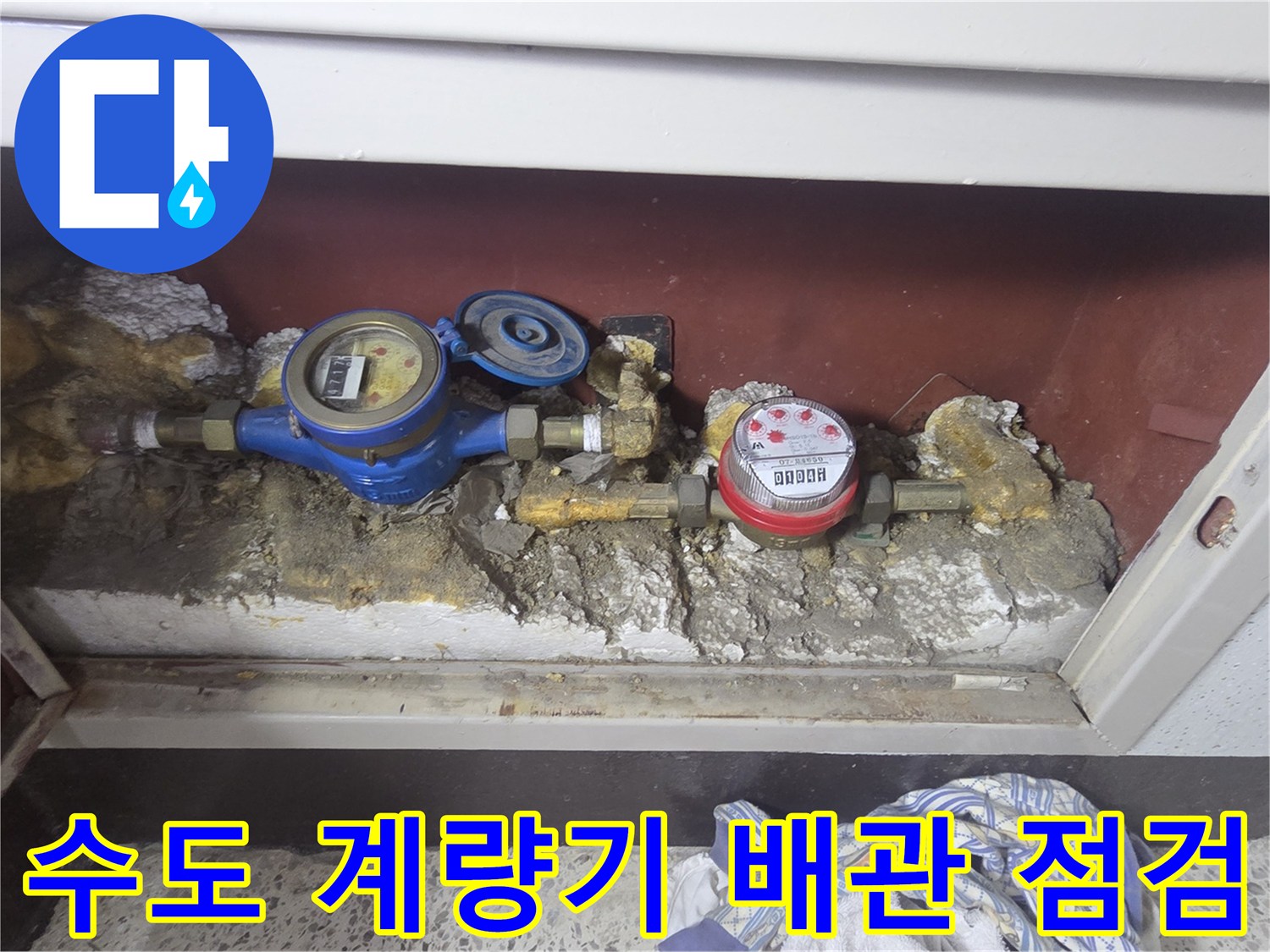 아파트 계량기함 내부의 수도 배관과 계량기 모습입니다.