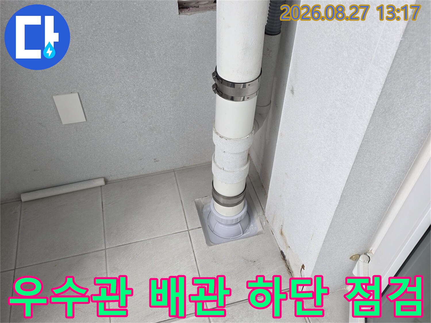 하얀색 우수관과 바닥 타일이 연결된 지점의 상세 사진