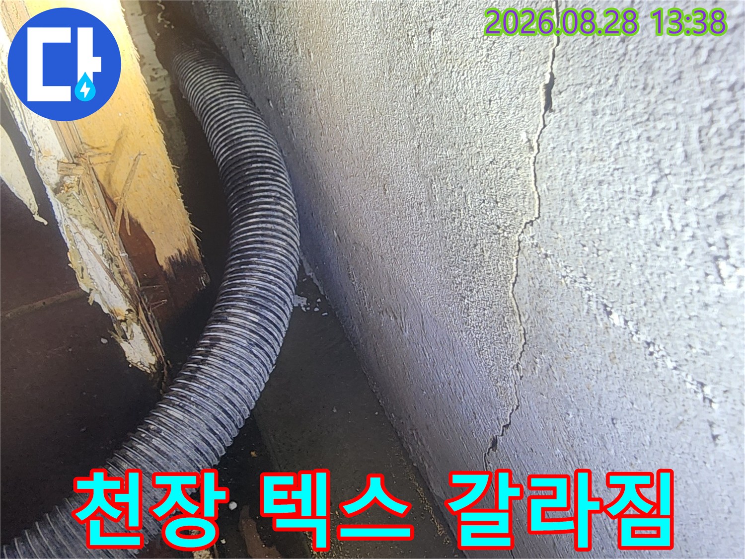 갈라진 천장 텍스와 주름진 배관의 근접 촬영