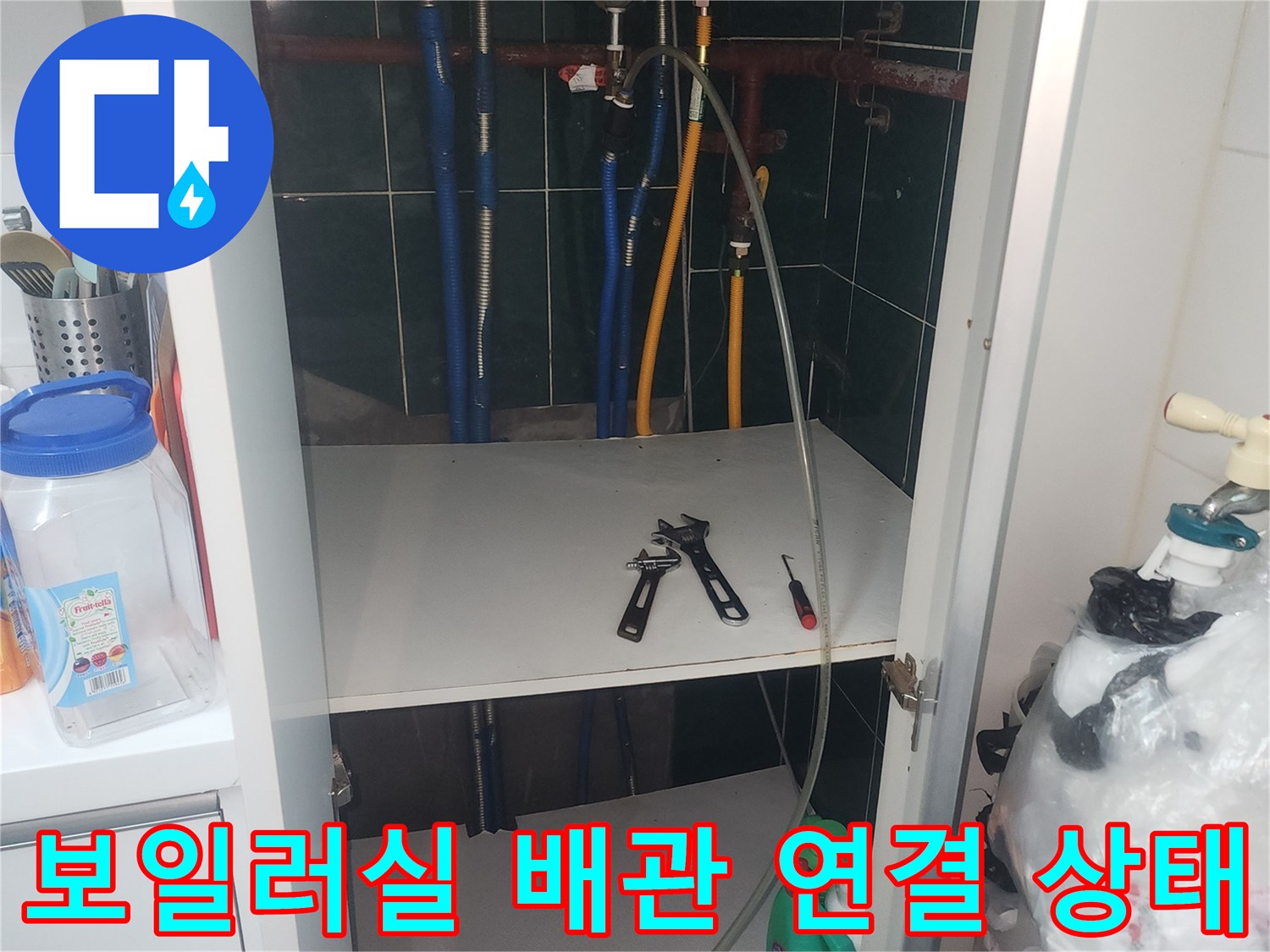 보일러 하단에 위치한 다수의 파란색 및 노란색 배관과 분배기 부위