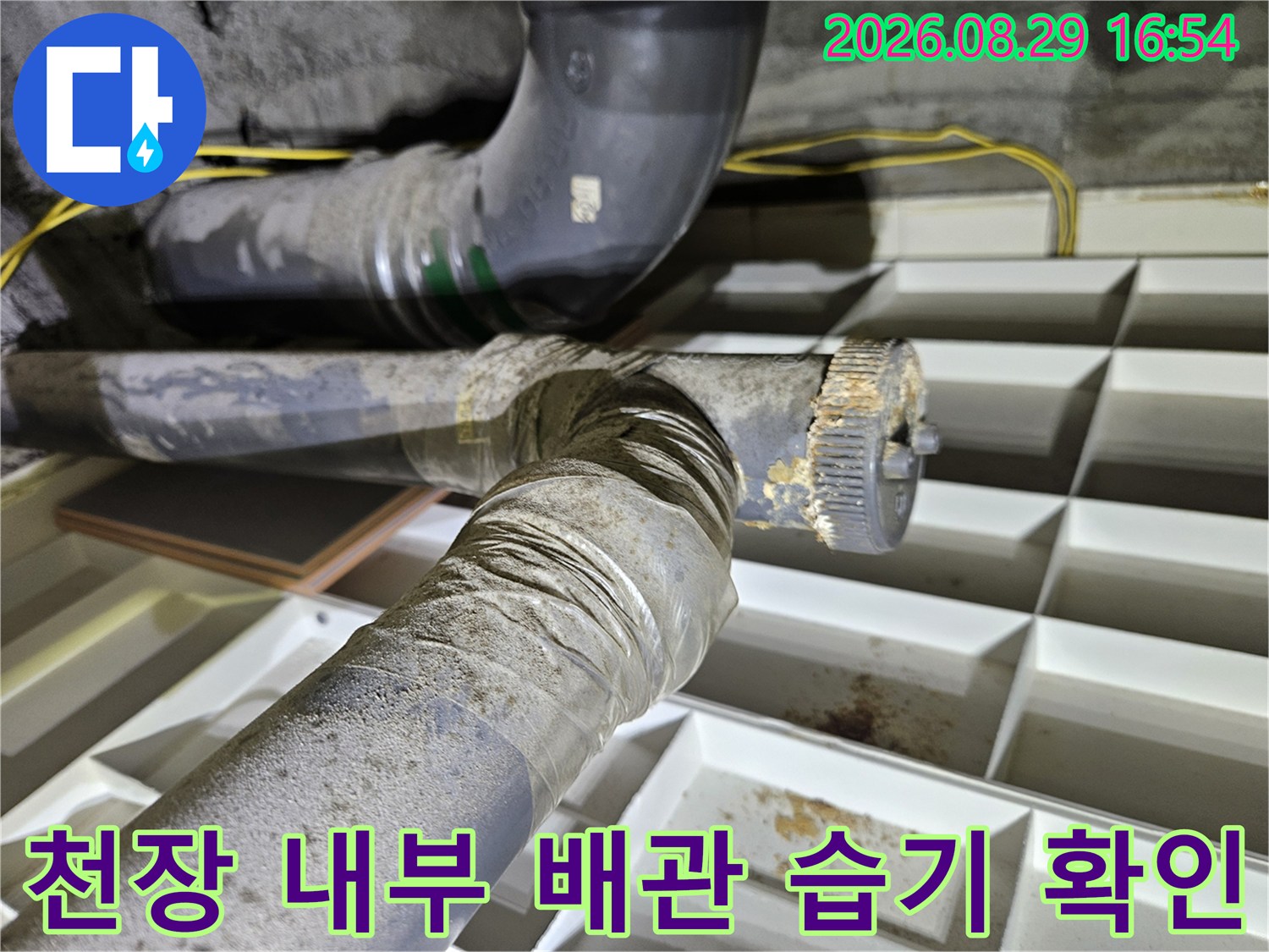 배관 연결 부위 주변에 발생한 물샘 흔적과 습기를 촬영한 사진입니다.