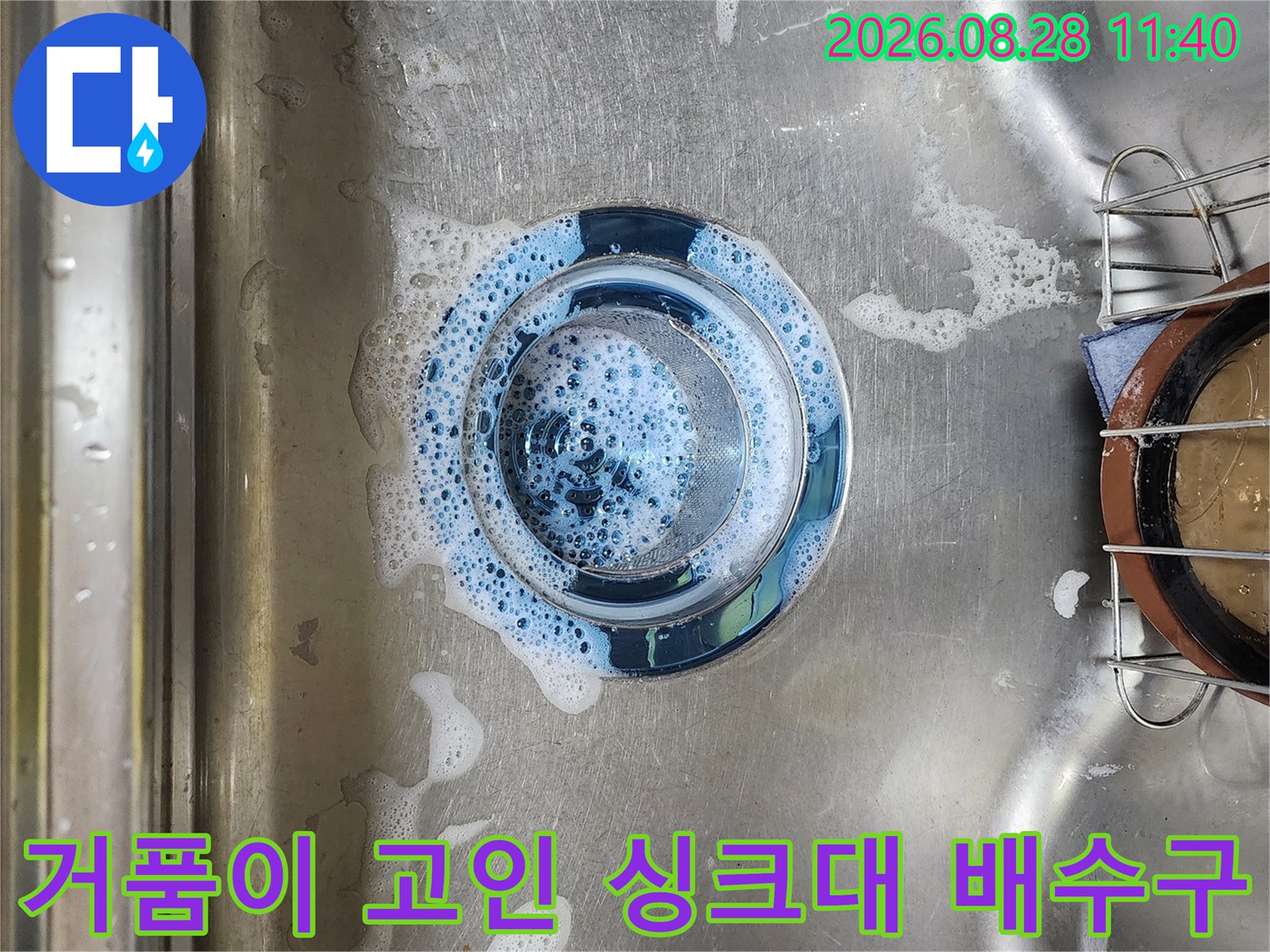 스테인리스 싱크대 배수구에 거품이 맺혀 있는 모습