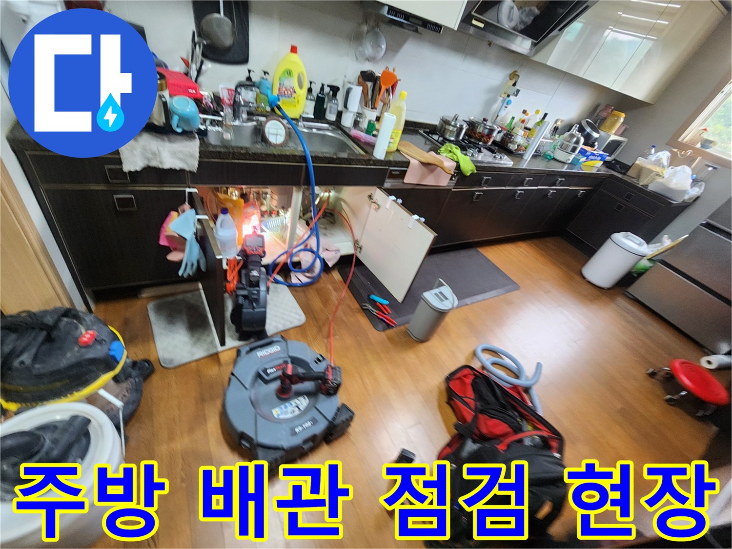 싱크대 하부 배관 구조와 에어컨 배수 라인을 확인하는 작업 상황