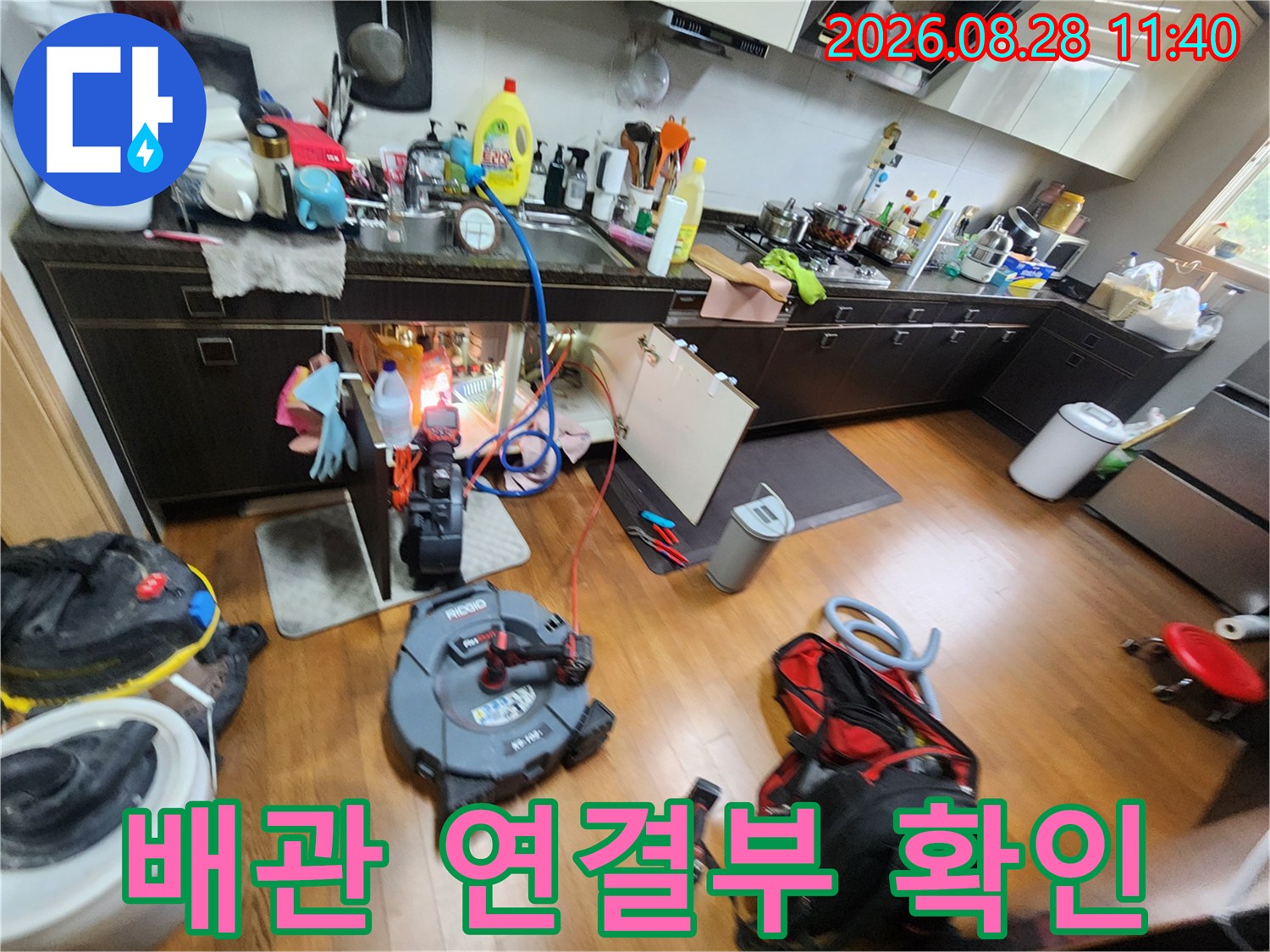 싱크대 하수구와 에어컨 호스의 연결 상태를 점검하는 장면입니다