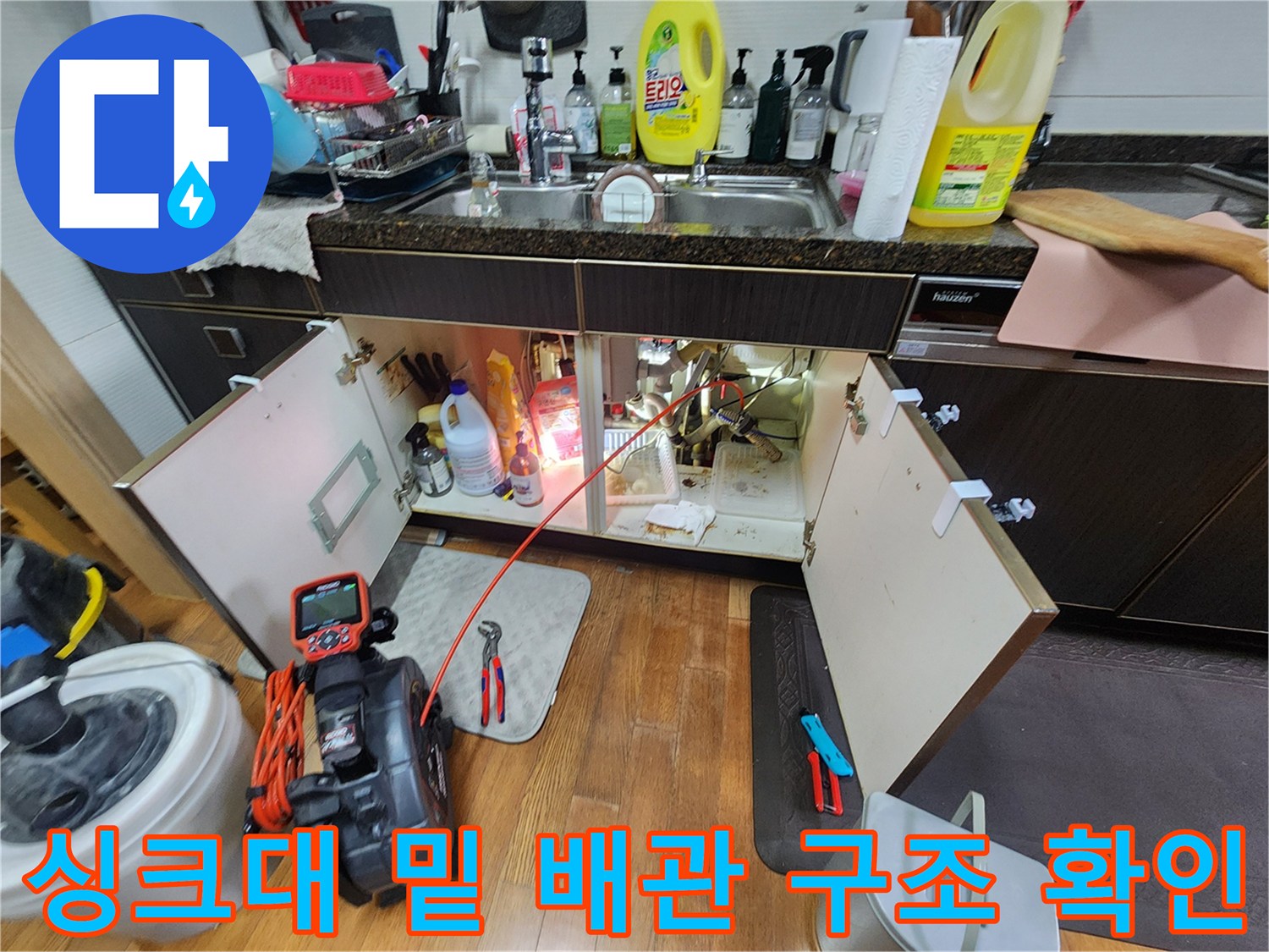 열려 있는 싱크대 하부장과 배관 연결 부위