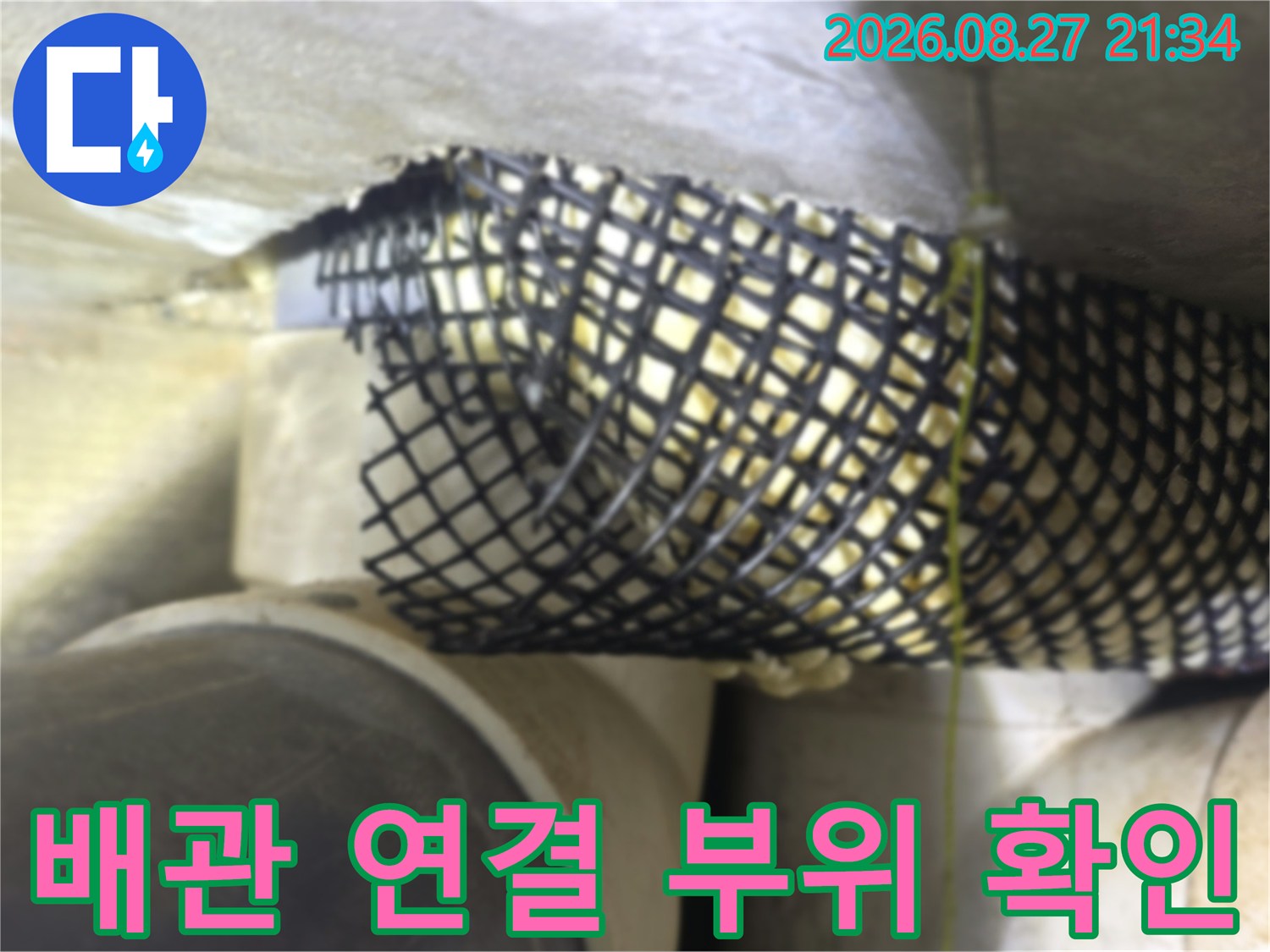 천장 배관의 연결 지점과 보호망 설치 상태를 촬영한 사진입니다.