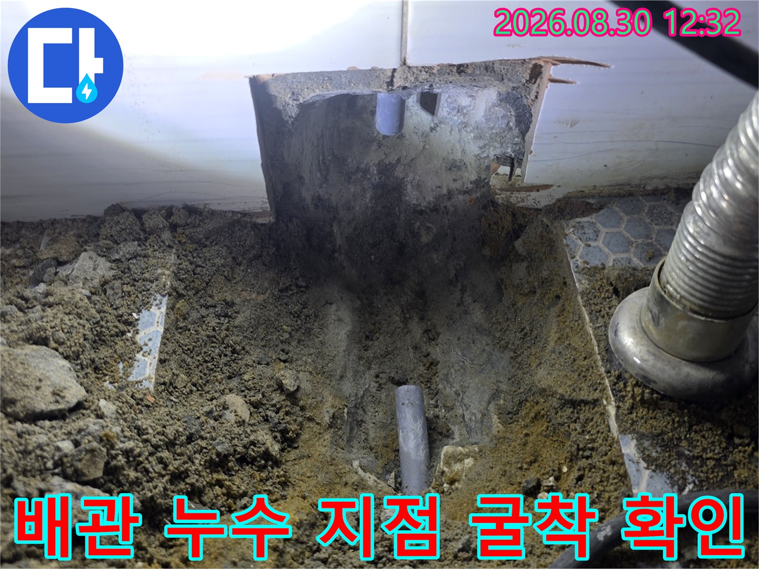 누수가 발견된-지면 아래의 회색 배관과-주변 흙 파헤친 모습