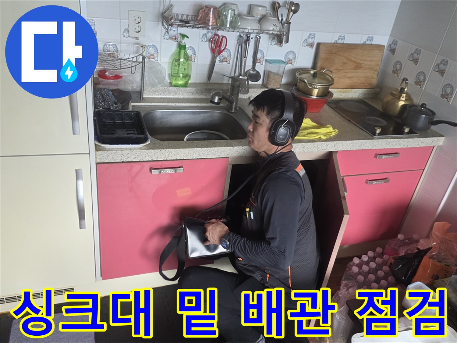 엔지니어가-청음 장비를 통해-싱크대 하부 배관을 검사함