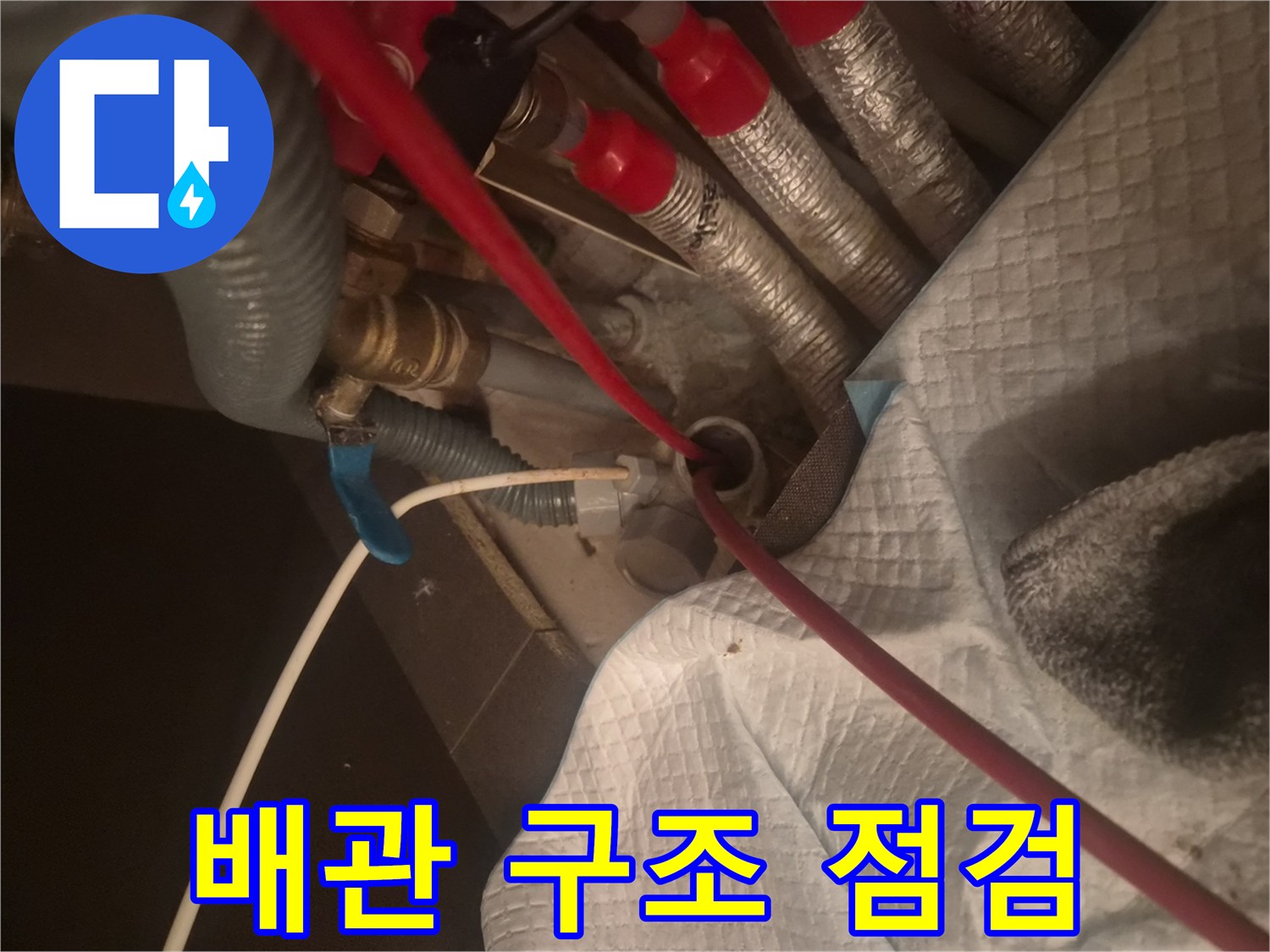 복잡하게 얽힌 주방 하부 배관과 작업용 호스 연결 상태