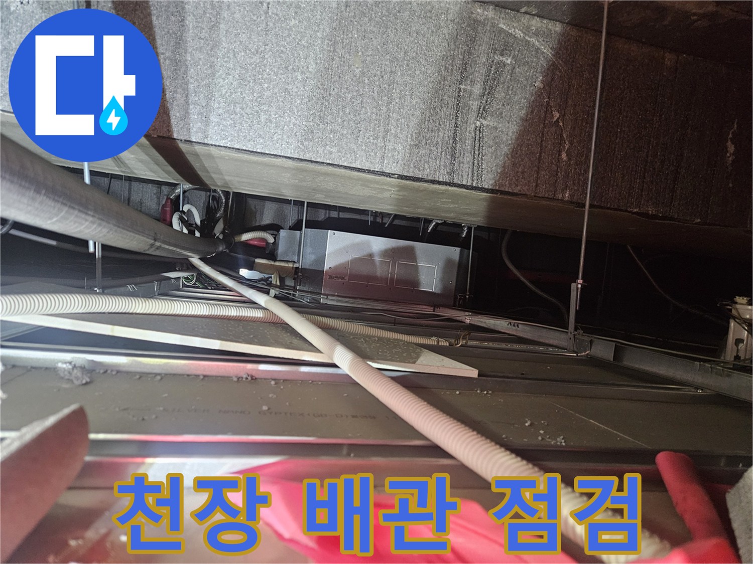 천장 내부의 복잡한 에어컨 드레인 배관 구조를 확인하는 모습