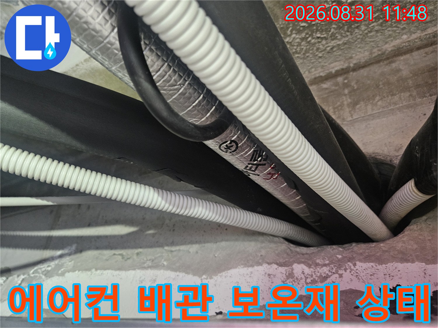 천장 내부의-하얀색 주름관과-검은색 보온재가 씌워진 에어컨 배관