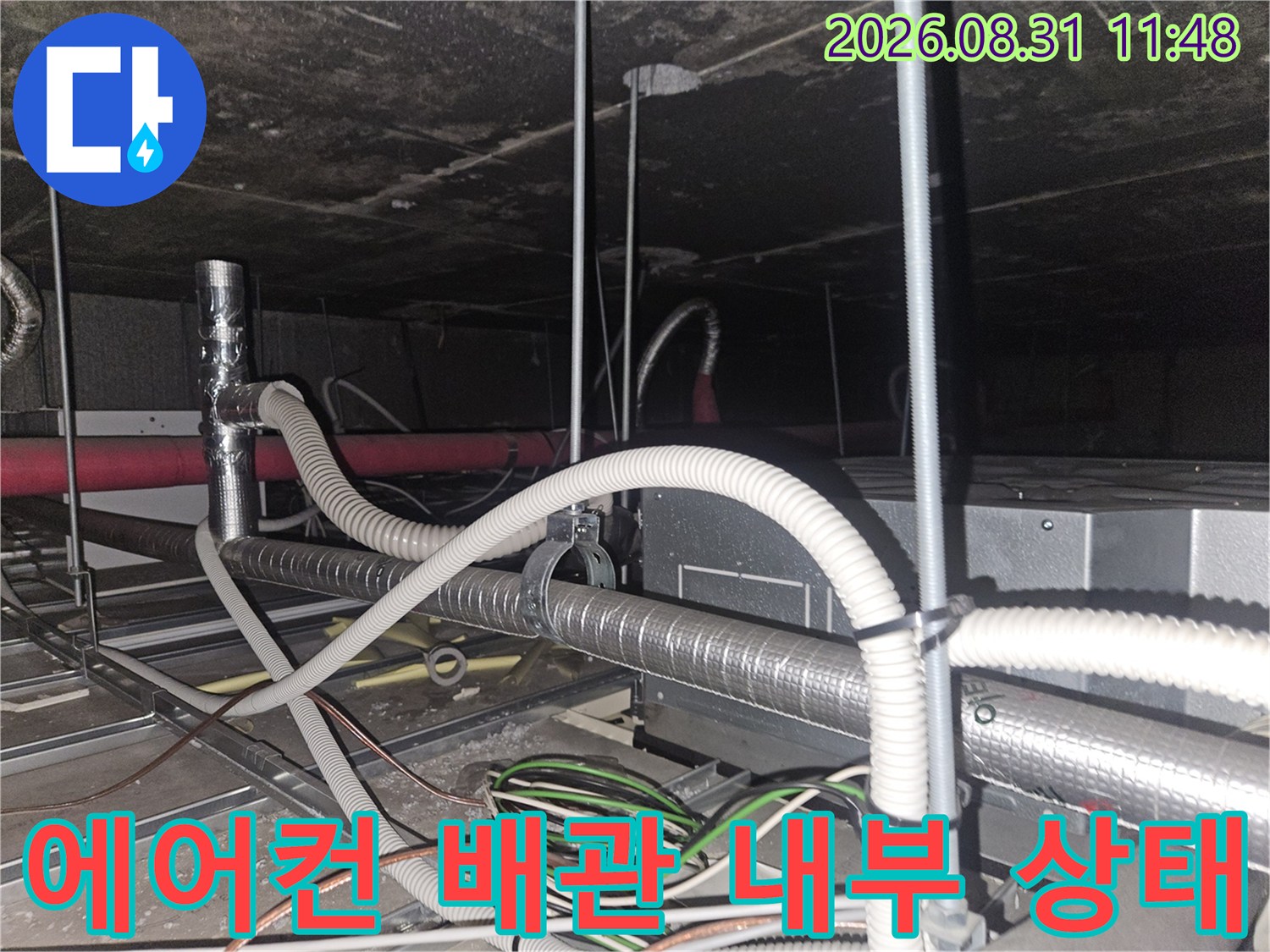 천장 안쪽 에어컨 드레인 호스와 은색 보온재로 된 배관의 연결 부위