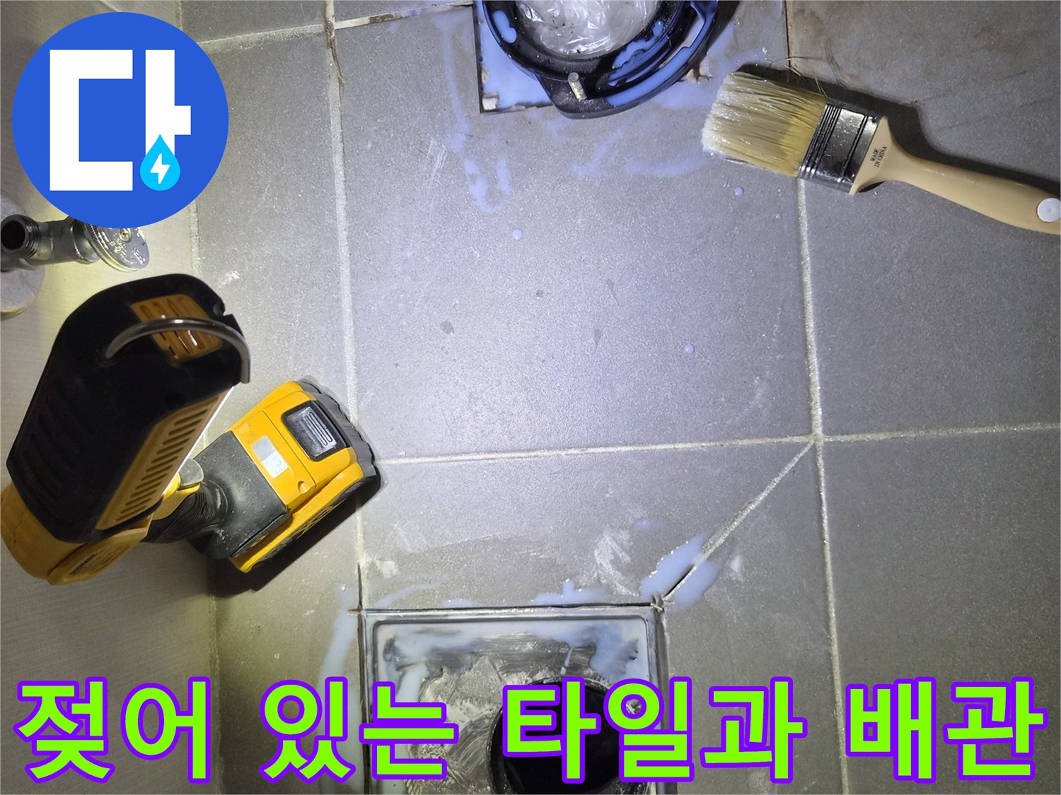 변기 제거 후 드러난 젖은 타일과 배수구 주변의 상태
