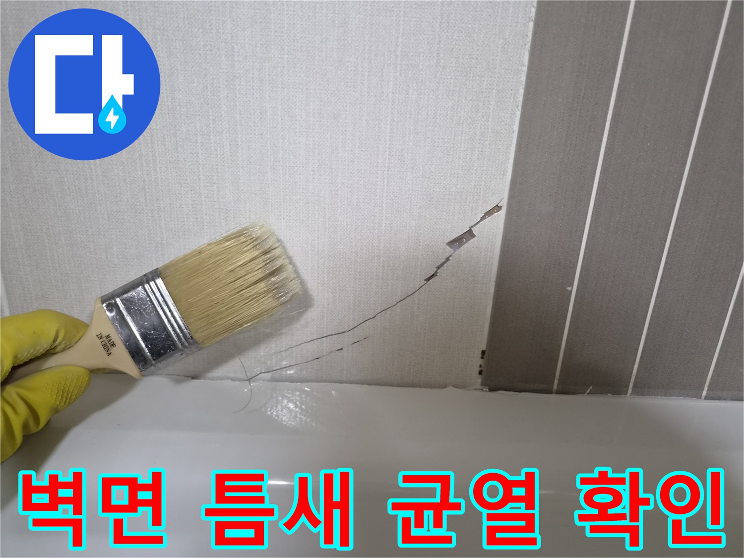 브러시로 벽면의 세로 균열 부위를 면밀히 관찰하는 작업자