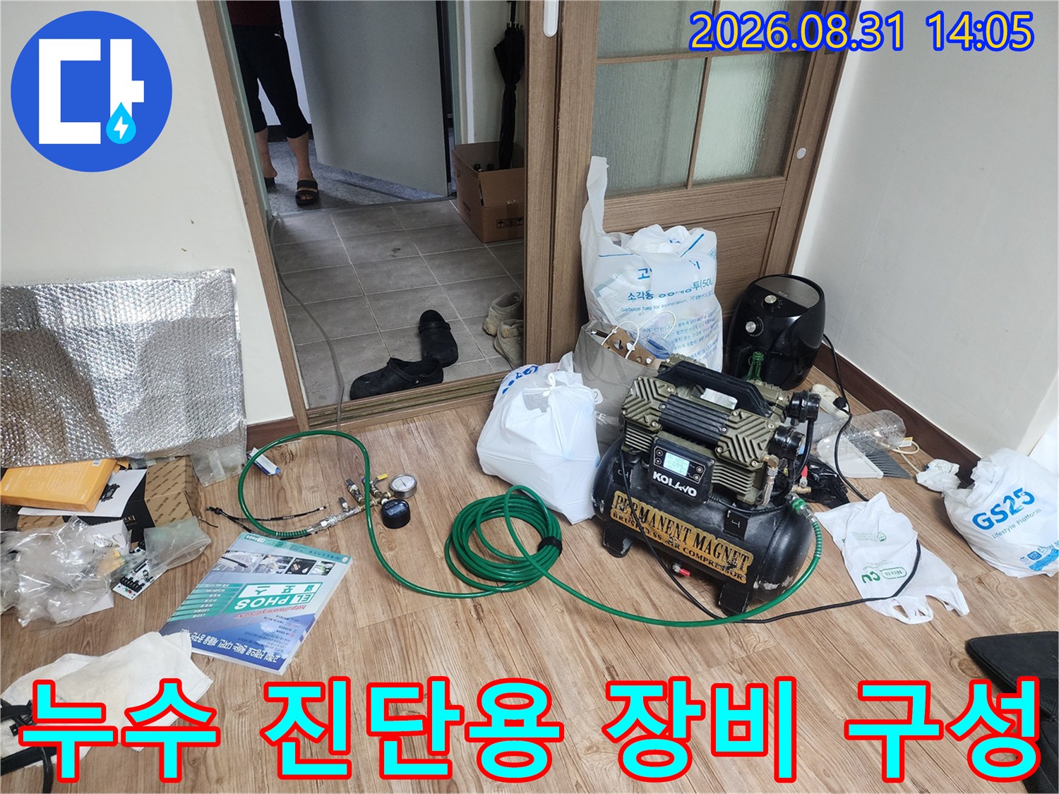 누수 탐지 작업을 위해 거실 바닥에 세팅된 공기 압축기와 호스들