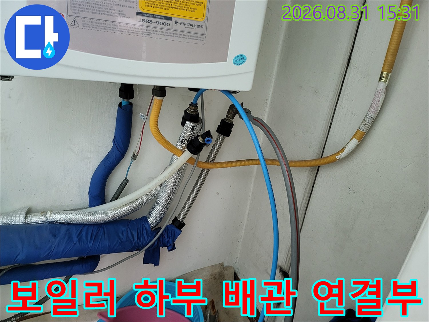 보일러 아래에 연결된 노란색 호스와 파란색 배관 사진