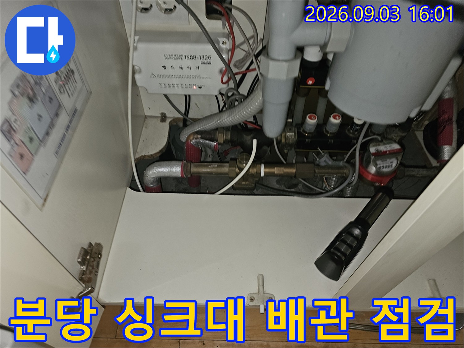 분당 백현동 아파트 싱크대 하부장 내부의 복잡한 보일러 배관과 연결 부위 모습입니다.